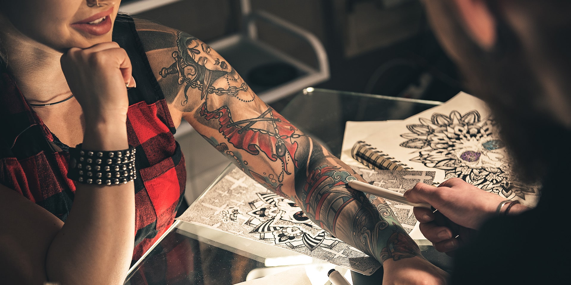 Female hand with tattoo situating on desk